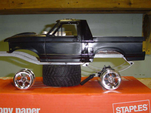 Black scale model Ford truck body on chassis with chrome wheels, side view