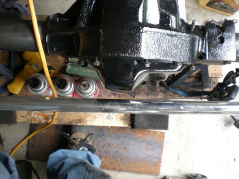 1993 Ford Bronco - A close-up view of a vehicle's differential assembly, with various tools and spray cans on a workbench.