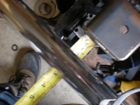 1993 Ford Bronco - A tape measure is used to check the dimensions of a vehicle suspension component.