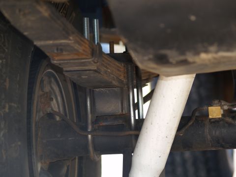 1989 Jeep Cherokee - Close-up view of the rear suspension system, showing modified leaf springs and a shock absorber.