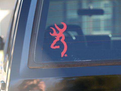 1989 Jeep Cherokee - A red Browning deer logo is applied to the rear window of a dark-colored SUV.