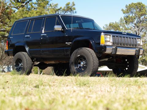 1989 Jeep Cherokee - This black Jeep Cherokee has a lifted suspension and aftermarket wheels, suggesting modifications beyond its original model year.