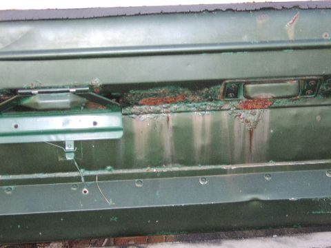 1986 Ford Ranger - The interior of a green vehicle door displays extensive corrosion and wear, particularly around the door handle mechanism.