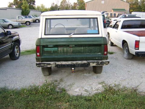 1986 Ford Ranger - Rear view of a green Ford Bronco with a white hardtop, parked outdoors on a gravel lot.