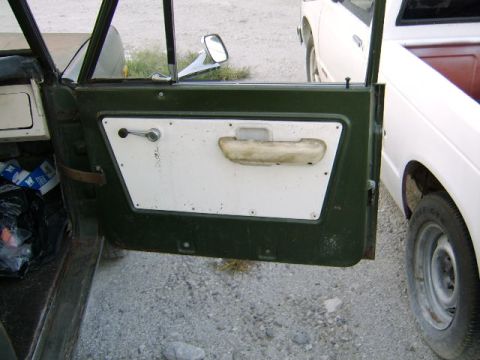 1986 Ford Ranger - Interior view of a green vehicle door next to a white truck.