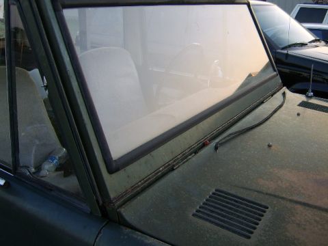 1986 Ford Ranger - Interior view of a green vehicle, showing the dashboard and seats. Another vehicle is visible through the windshield.