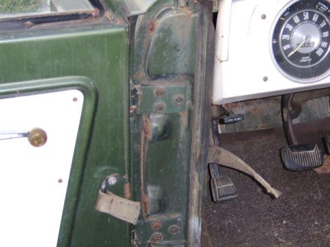 1986 Ford Ranger - Interior view of a green vehicle, showing the door frame, dashboard, and pedals, with visible signs of wear and rust.