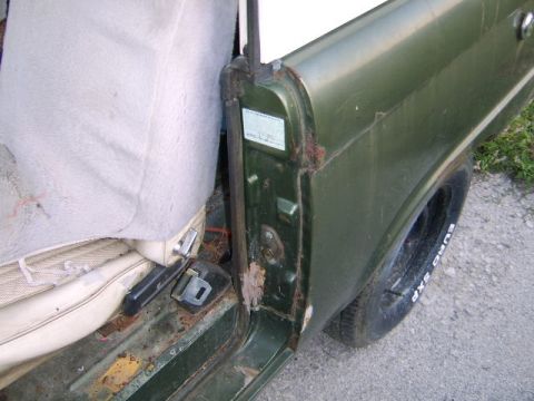 1986 Ford Ranger - Interior view of a green 1986 Ford Ranger, showing the door jamb, seat, and some rust.