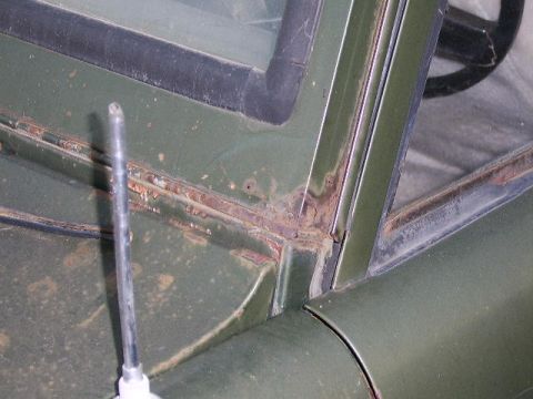 1986 Ford Ranger - Rust is visible around the windshield frame of a green vehicle, with an antenna in the foreground.