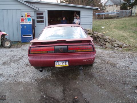 1991 Pontiac Firebird - Rear view of a red 1991 Pontiac Firebird Formula, a spoiler and a custom license plate.