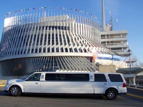 1991 Ford Crown Victoria - A white limousine is seen parked in front of a distinctive modern building under a clear blue sky.