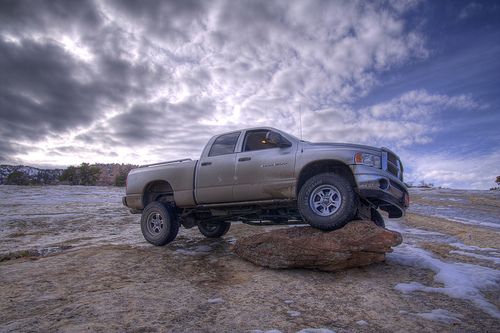 Dodge Ram pickup truck on a rock, cloudy sky