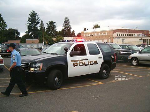 1991 Ford Crown Victoria - A Gresham Police SUV is parked in a lot with a police officer walking nearby.