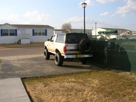 1996 Ford Bronco - This 1996 Ford Bronco is parked in a driveway next to a green fence.
