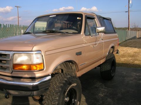 1996 Ford Bronco - This lifted Ford Bronco features a soft top and aggressive off-road tires, ready for adventure.