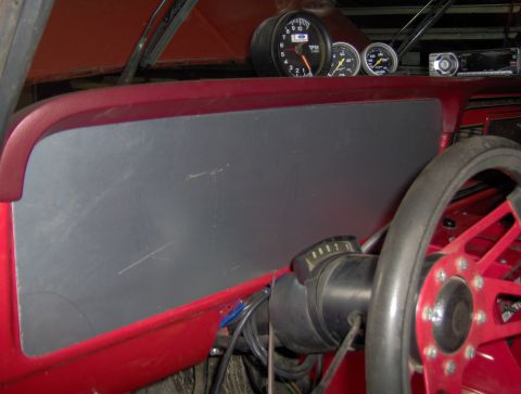 1978 Ford Bronco - Interior view of a 1978 Ford Bronco dashboard, a tachometer, speedometer, and a red aftermarket steering wheel.