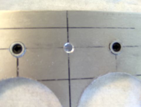 1978 Ford Bronco - A close-up view of a metal plate with pre-drilled holes and layout lines.