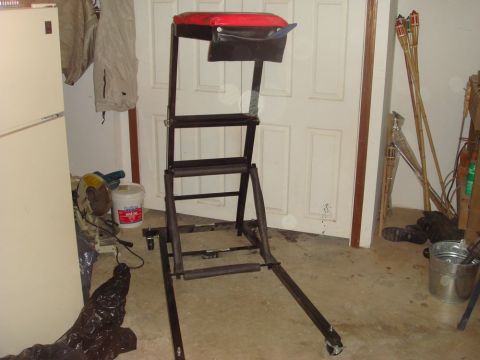 1996 Ford Bronco - A black and red padded seat on a metal frame with wheels is shown in a garage setting.