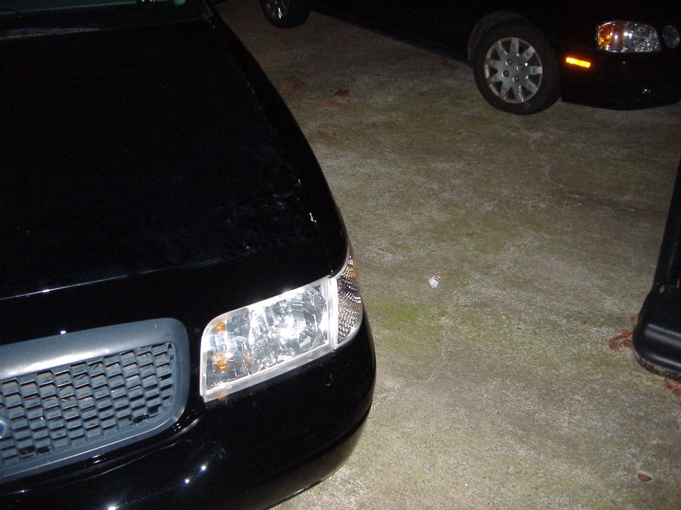 Front corner of a black sedan parked next to another car