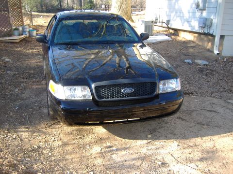 2001 Ford Crown Victoria - Front view of a black 2001 Ford Crown Victoria, showing the grille and headlights.
