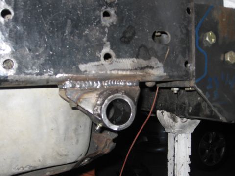 1994 Ford Bronco - Welding work on a vehicle's frame, showing a newly attached bracket and part of the fuel tank.