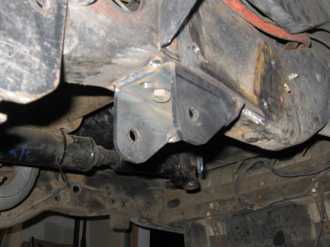 1994 Ford Bronco - Close-up view of a custom-welded suspension bracket attached to the vehicle's frame, with a driveshaft in the foreground.