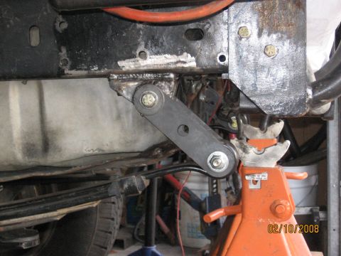 1994 Ford Bronco - Custom suspension linkage modification shown on a vehicle frame, supported by a jack stand.
