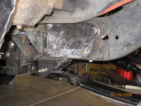 1994 Ford Bronco - A close-up view shows a custom metal plate bolted to the vehicle's frame, likely for modification or reinforcement.