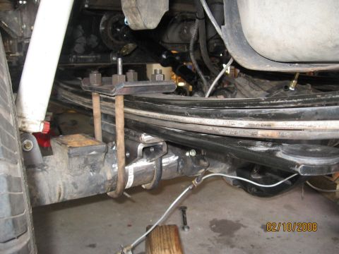 1994 Ford Bronco - Close-up view of a vehicle's rear axle suspension system, showing leaf springs and U-bolts.