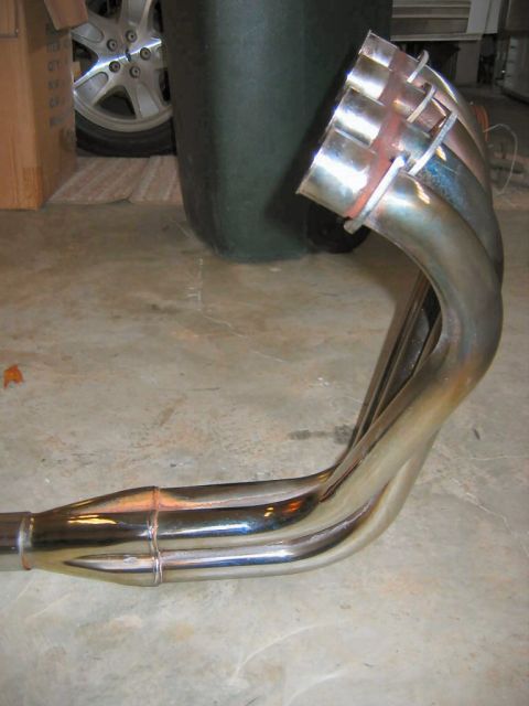1985 Ford LTD Crown Victoria - A close-up view of a custom exhaust manifold, showing its intricate pipework and metallic finish.