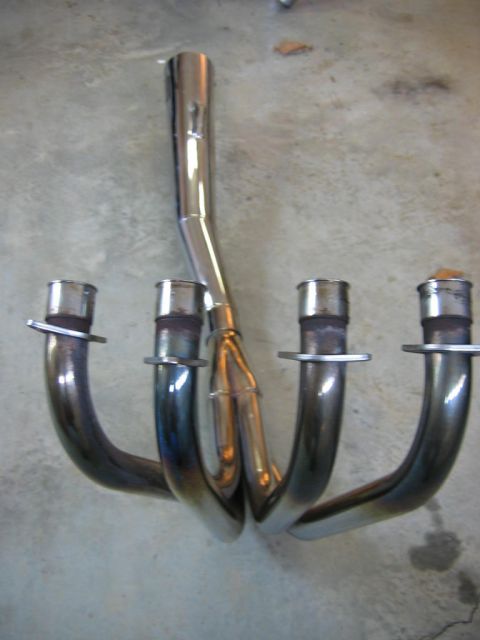 1985 Ford LTD Crown Victoria - Four-into-one exhaust header pipes, likely for a motorcycle, are shown from above.
