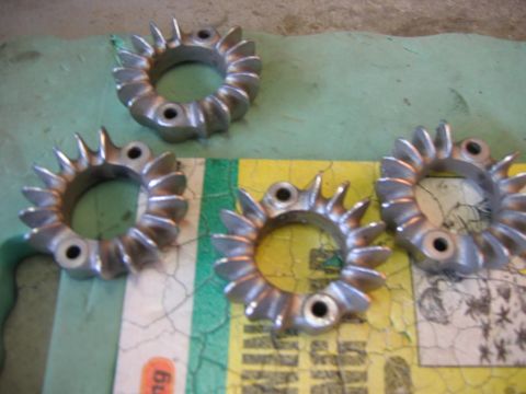 1985 Ford LTD Crown Victoria - Four metal clamps with a finned design are laid out on a surface.
