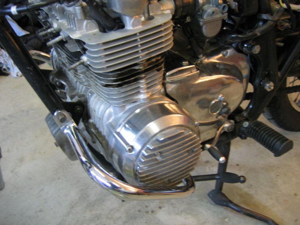 Motorcycle engine with chrome exhaust pipe and black frame