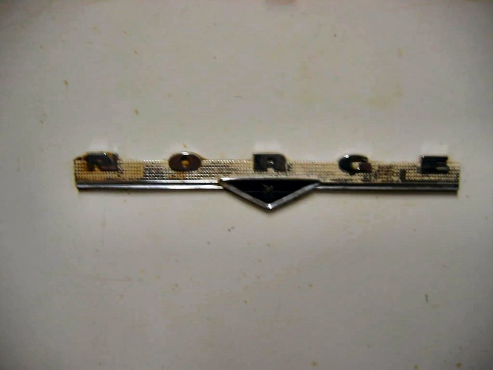 Chrome badge spelling NORAGE on a white surface
