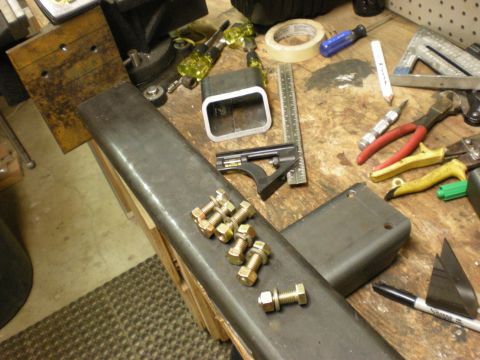 1993 Ford Bronco - A collection of bolts and tools are laid out on a workbench, suggesting a project in progress.