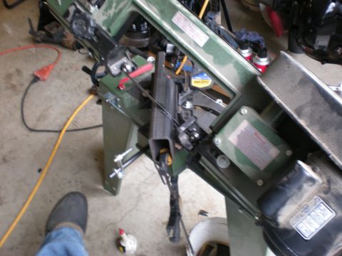 1993 Ford Bronco - A green metal cutting band saw is shown in a workshop setting with various tools and cords around it.