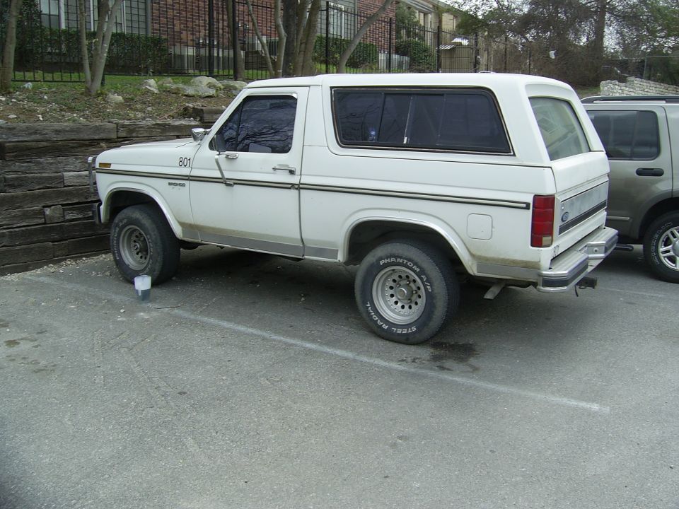 White Ford Bronco parked next to a silver SUV