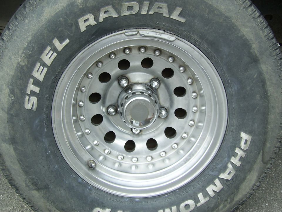 Close-up of a polished aluminum wheel with a "Steel Radial Phantom" tire