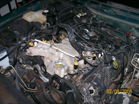 1995 Mercury Grand Marquis - Close-up view of an engine bay, focusing on the intake manifold and fuel injectors. A date stamp indicates the photo was taken on February…