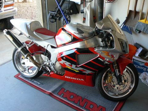 1978 Ford Bronco - A red and silver Honda RC51 motorcycle is parked on a Honda-branded mat inside a garage.
