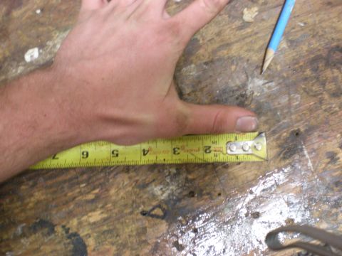 1993 Ford Bronco - A hand is shown using a tape measure to measure a length on a wooden surface.