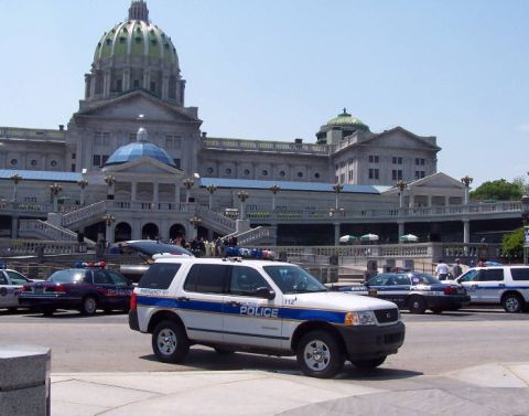 1991 Ford Crown Victoria - Several police vehicles are parked in front of a large domed building.
