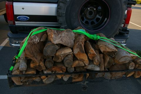1986 Ford Bronco - Firewood is strapped to a trailer hitch behind a Ford Bronco.