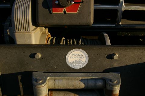 1986 Ford Bronco - Close-up of a vehicle's front bumper and winch, with a "Mall Rated 4x4" emblem visible.