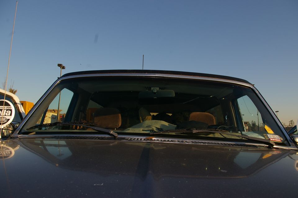 1986 Ford Bronco interior, view through windshield showing brown seats and dashboard