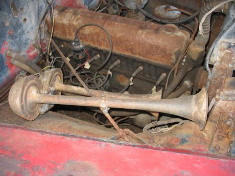 1949 Chevrolet C/K Pickup - View of the engine bay, dual horns and significant rust on engine parts.