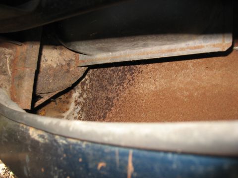 1949 Chevrolet C/K Pickup - Detail shot of heavily rusted metal frame components beneath a blue exterior panel.