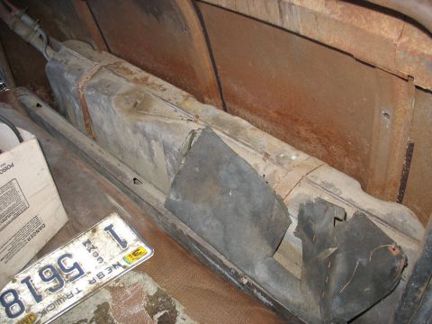 1949 Chevrolet C/K Pickup - The interior of an old vehicle shows a fuel tank and significant rust on the floor panels.