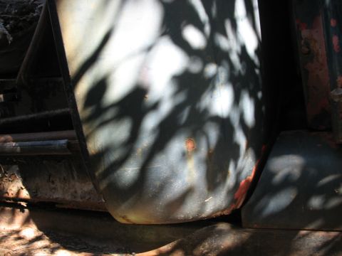 1949 Chevrolet C/K Pickup - A close-up view of a vehicle's fender, obscured by shadows and showing signs of rust.