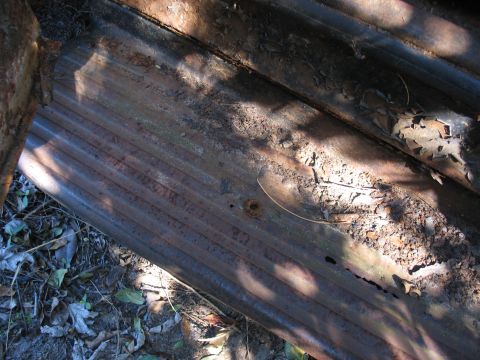 1949 Chevrolet C/K Pickup - Close-up of weathered corrugated metal with dirt and leaves scattered on its surface.
